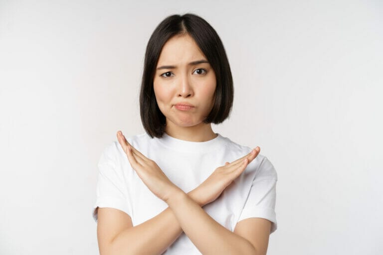 portrait asian korean woman showing stop prohibition gesture showing arm cross sign standing tshirt white background copy space