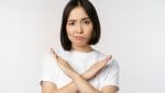 portrait asian korean woman showing stop prohibition gesture showing arm cross sign standing tshirt white background copy space